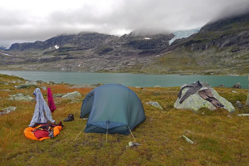 Telt ved vannet Skåltjørna med Hardangerjøkulen i bakgrunnen.